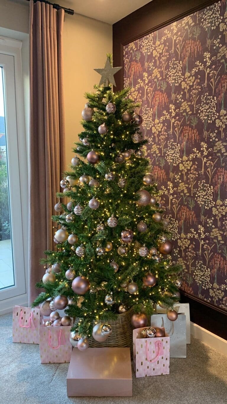 Christmas tree with blush and silver baubles and pink wrapped presents in a showhome