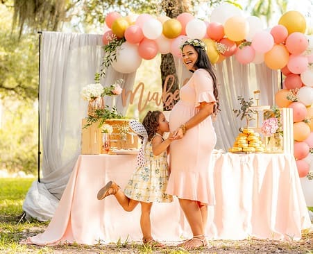 Baby shower styling with a peach balloon arch and dessert table