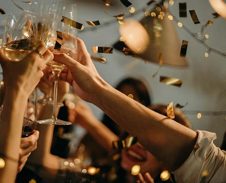Guests raising champagne glasses in a toast at a styled celebration