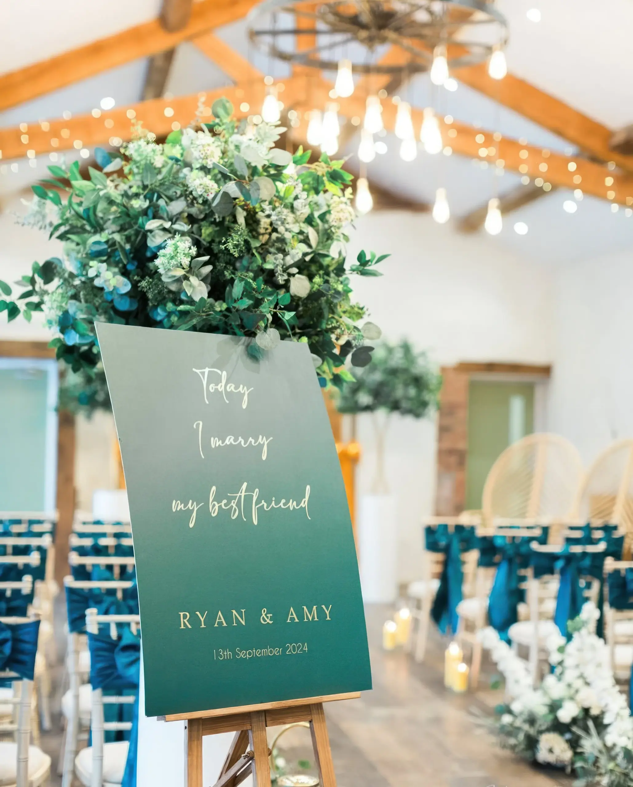 Teal wedding welcome sign with foliage at Bennetts Willow Barn