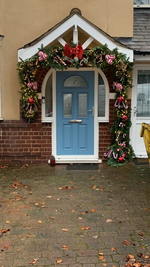 Christmas garland door arch with red ribbons on a Worcestershire home