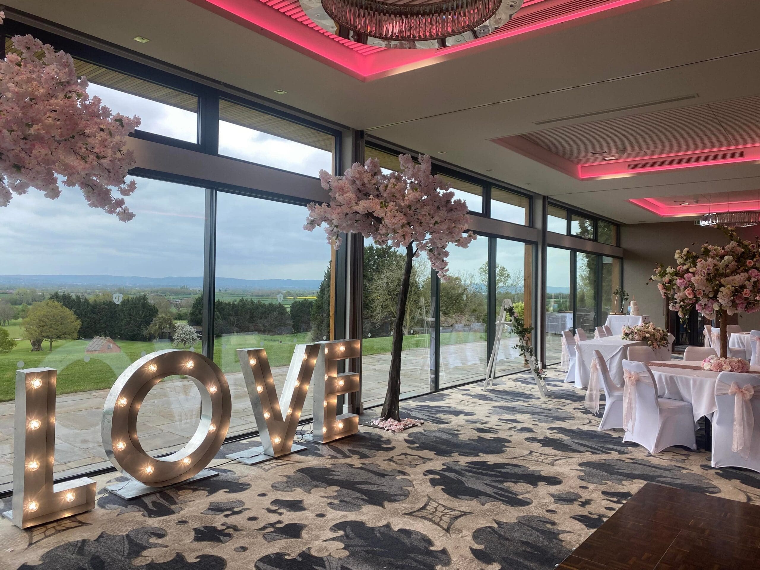 Illuminated LOVE letters and blossom trees at a Tewkesbury Park wedding