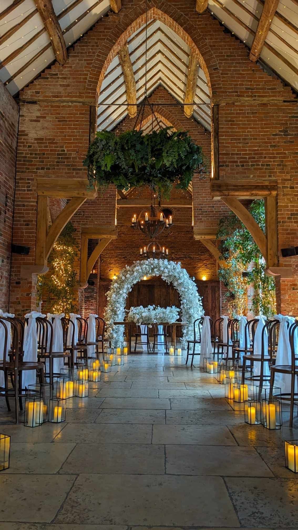 Floral moon gate and candlelit aisle at a Shustoke Barn wedding