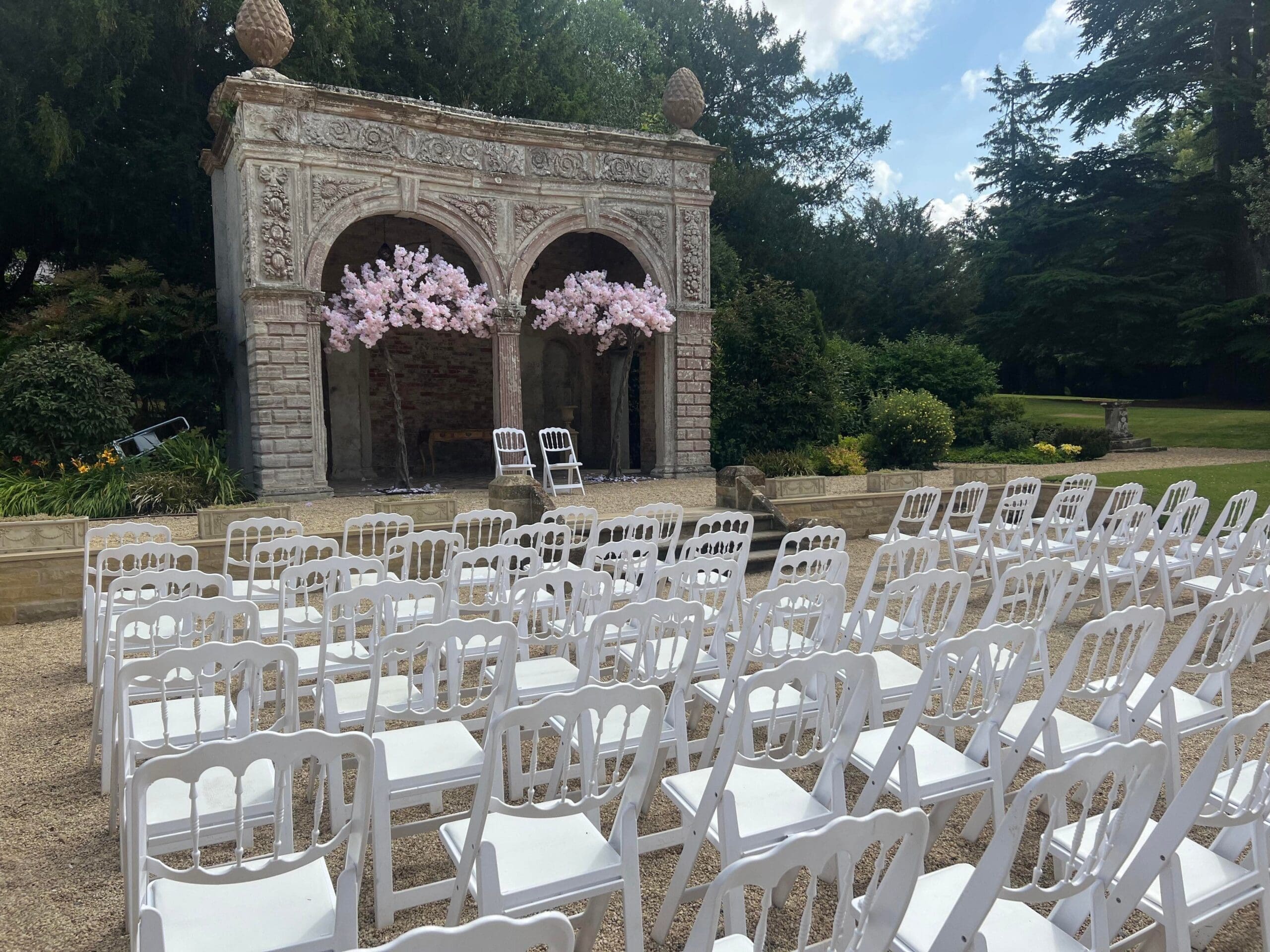 Outdoor ceremony seating facing a stone archway at Ettington Park