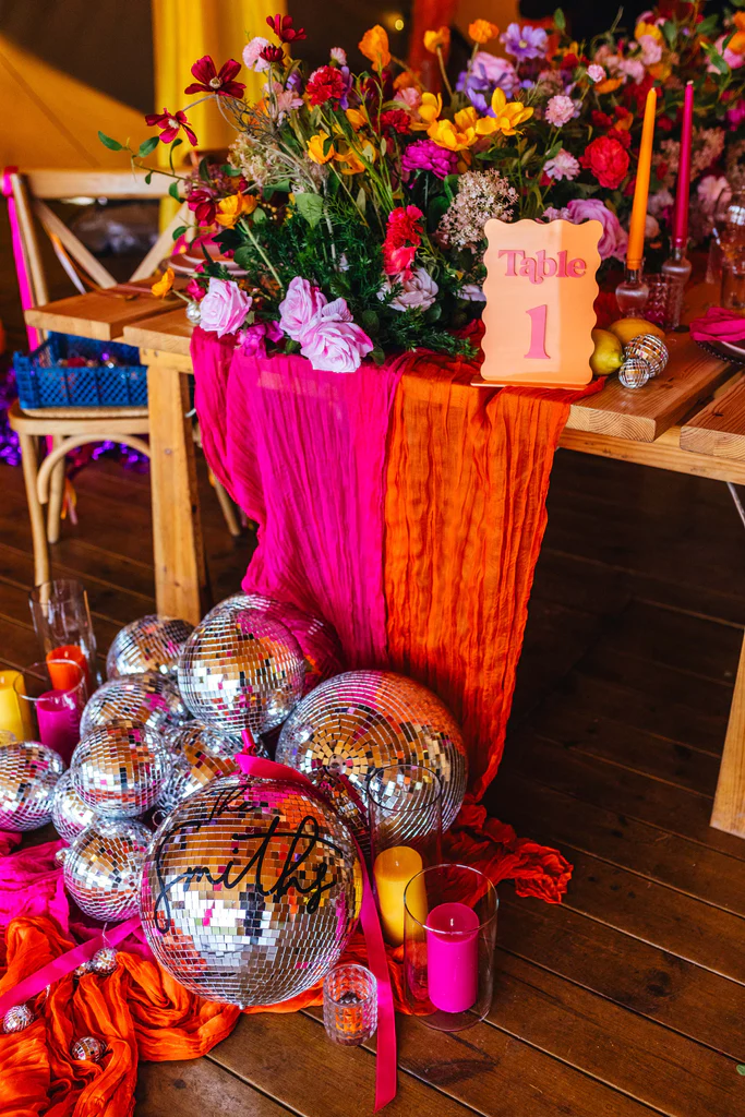 Bright festival wedding florals with disco balls in hot pink and orange