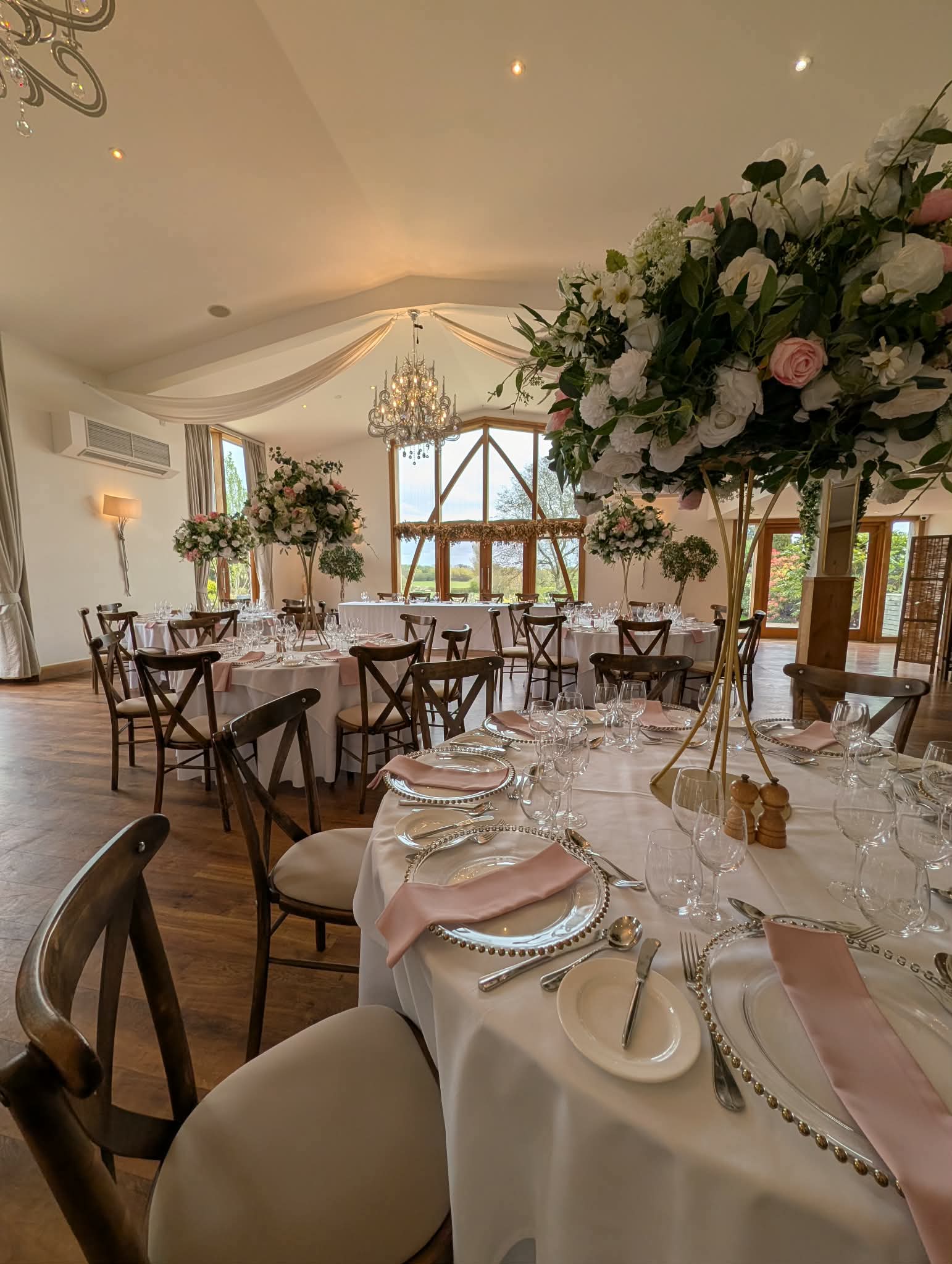 Wedding table styling with silver charger plates, pink napkins and floral centrepieces