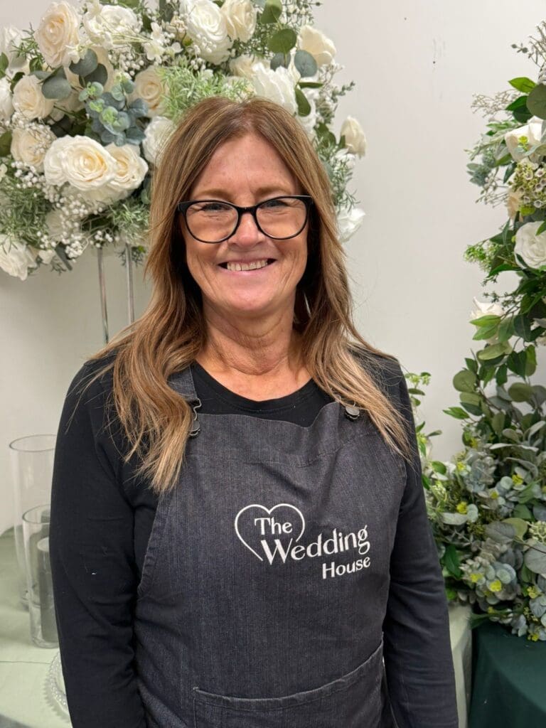 Tay, venue stylist at The Wedding House, with floral arrangements in Droitwich Spa