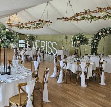 Wedding reception decor with styled tables, floral centrepieces and elegant venue styling by The Wedding House Worcestershire
